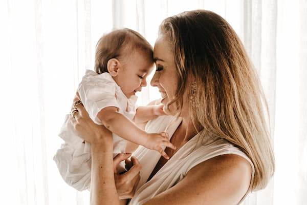 Madre abrazando sonriente a su bebe